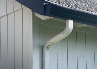 JT Wide Fascia gutter in black to match the trim, with 3x4 corrugated downspouts in gray to match the siding